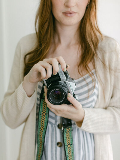 Faceless Eugene wedding photographer holding a camera, representing her offering of both film and digital images. 