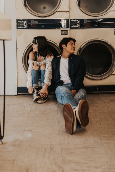 man and woman sitting at the laundry mat