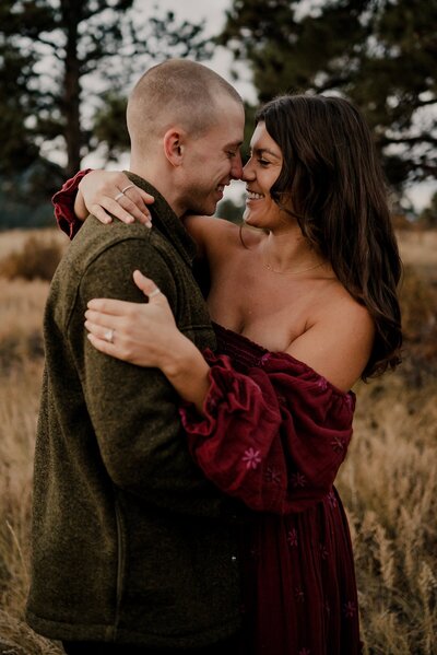 Engaged couple hold signs saying he asked, she said about time