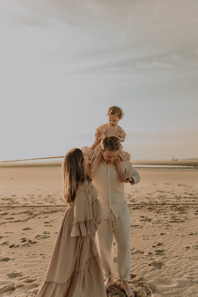 Gezin poseert op het strand voor familie fotoshoot