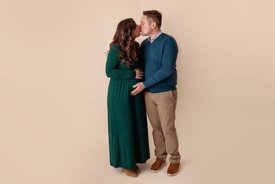pregnant couple standing in studio kissing by philadelphia maternity photographer