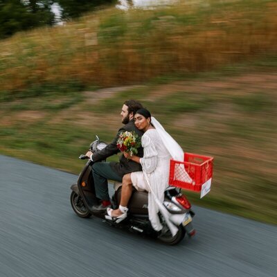 Bride and groom riding on moped taken by luxury destination wedding photographer Noble Photo Co