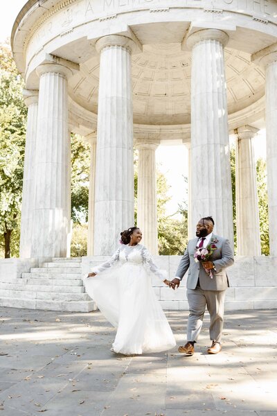 Groom-kisses-bride- on temple- in front of elopement ceremony arch in  Virginia forest