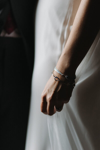 detail shot of brides jewelry and dress