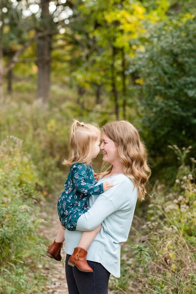 Mother holding daughter with their noses touching, smiling at eachother | fall family session Chicago-area