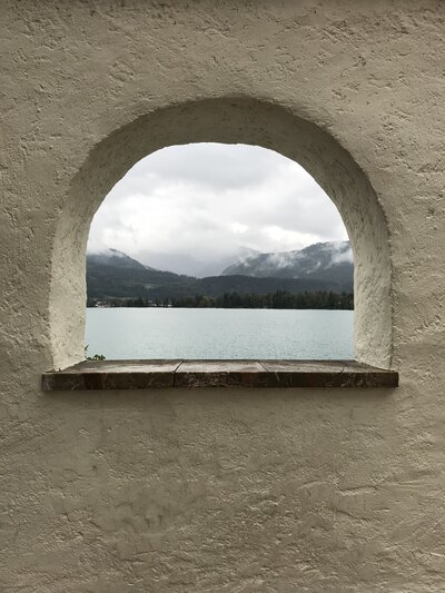 curved window overlooking water in Austria, image taken by Caroline Amelie