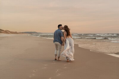 Family walking barefoot on the beach photographed by Michigan photographers