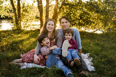 Family of four sitting on the ground during golden hour