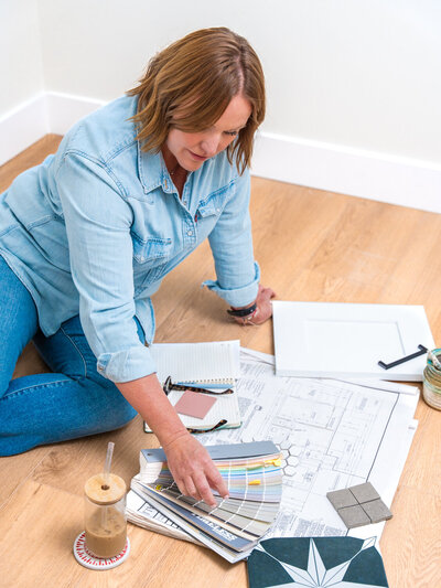 Interior designer on the ground with finish materials spread around her