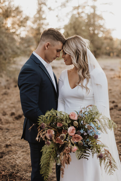 Couple sharing an intimate moment outside a rustic cabin near Los Angeles, with a warm sunset casting a golden glow over the surrounding forest.