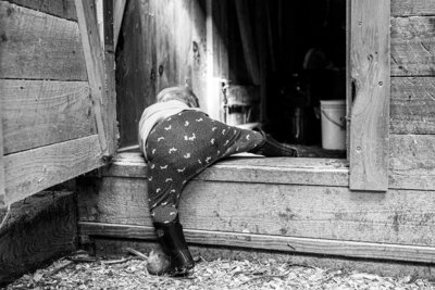 Child holding a camera close to their face, focused and curious, captured by a documentary photographer in New Paltz.