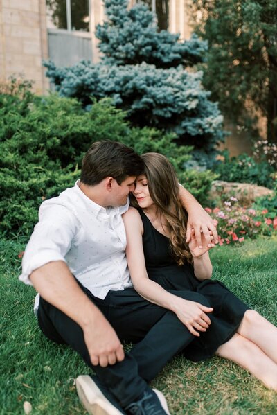 couple sitting in a garden with closed eyes and arms wrapped around each other by Colorado Wedding Photographer JKG Photography