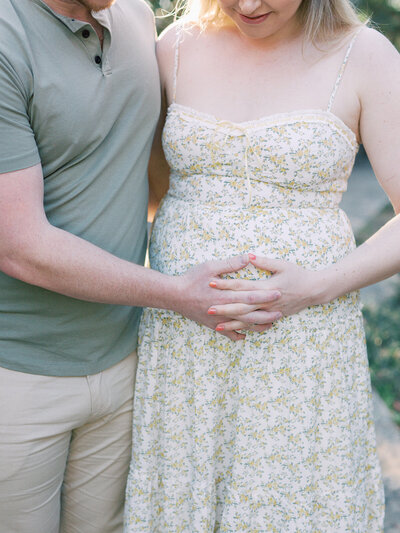 A couple holding the mother's pregnancy bump during a maternity photography session in Richmond by Katie Stansfield Photography.