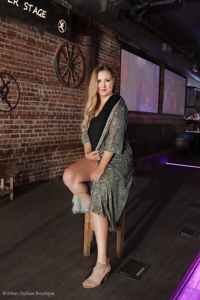 Blonde female sitting on a bar stool