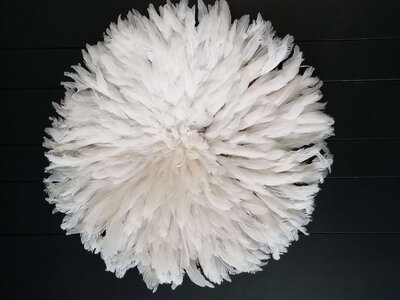 a white feathered circle piece on a black surface