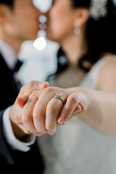 Groom holding bride's hand out to show wedding rings