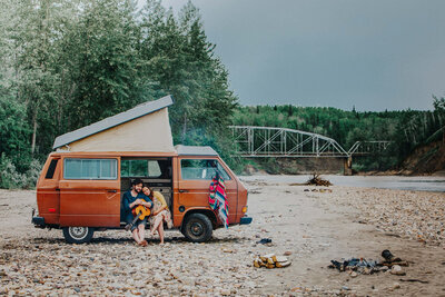 expecting parents on beach with Volkswagen van