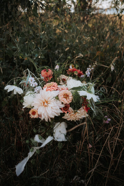 A bride and groom walk up the aisle after getting married, being showered in flower petals.