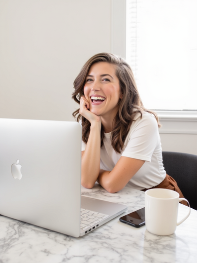 Young woman smiling while working in her Macbook