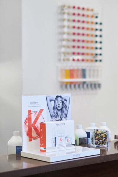 Kerastase haircare product display at Denise Antonacci Salon in Charlotte, NC, with color swatches in the background. Captured by DeLong Photography as part of a branding session for hairstylist Steph Dillard. Ideal example of clean, modern salon branding photography for beauty professionals.