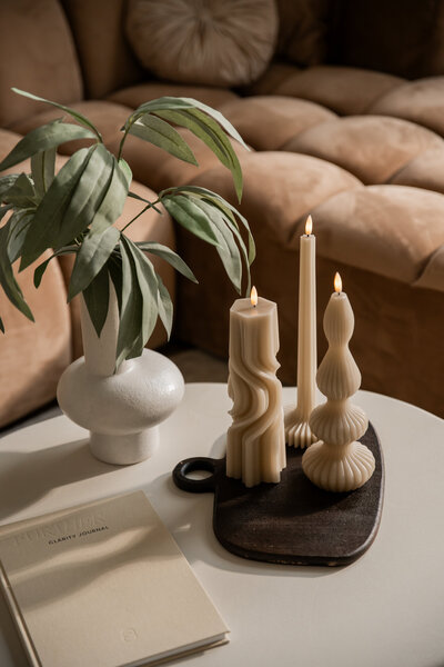 Productfoto shoot van kunstbloemen in een vaas op een organische tafel, met zonnestralen en een prachtig schaduwspel.