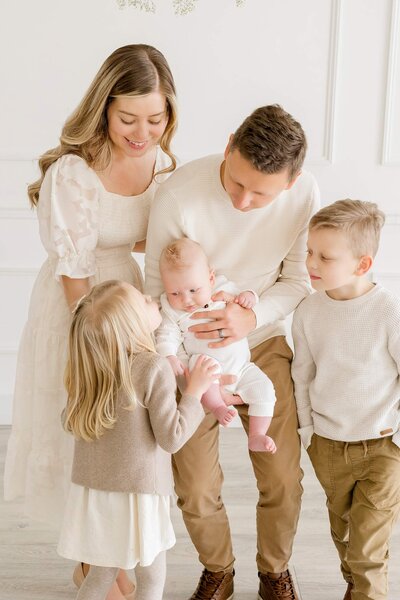 Father holds baby in newborn family photoshoot in Minnesota.