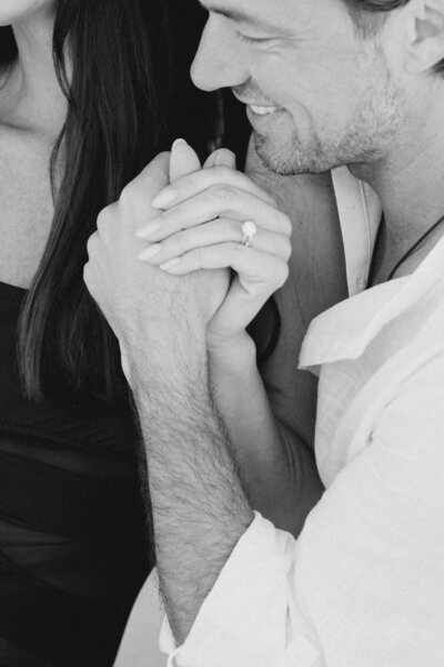 Couple holding hands and the beach showing wedding ring