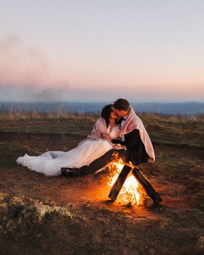 couple by fire at the mountains