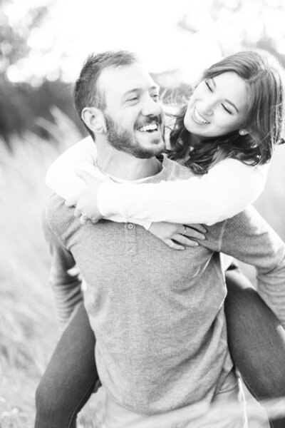 Woman getting a piggyback ride from fiancee during Minneapolis engagement shoot.