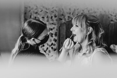 Behind-the-scenes of Abby Kaye applying makeup on the mother of the bride, showcasing a natural and elegant look.