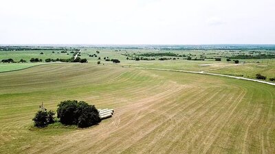 Aerial view of 11-acre property in Lindsay, Texas with open fields and clear skies