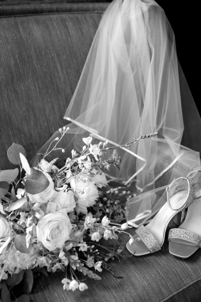 Black and white flat lay of wedding shoes, bouquet, and bridal veil | Megan Smith Photogrpahy