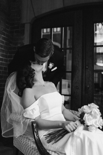 black and white groom kissing bride