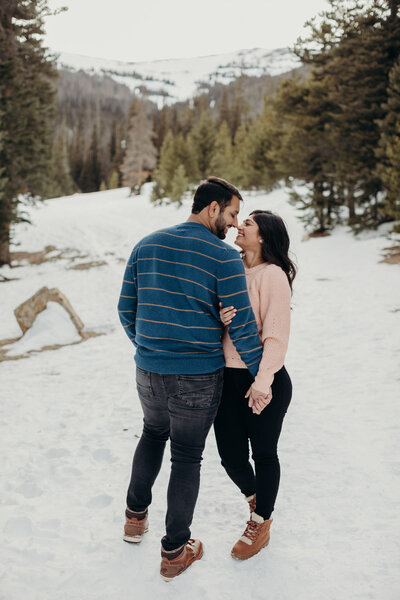 mountain engagement photos in Colorado spring, couple walking through wildflowers