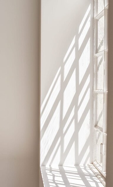 shadows of window frame on tan wall