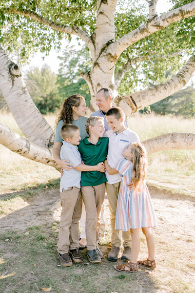 family of six huddled together laughing and smiling
