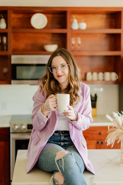 Woman holding coffee smiling at camera