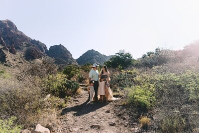Big Bend elopement photographer captures a tender family moment in the desert mountains of West Texas, with golden light, cacti, and rugged peaks framing the scene.
