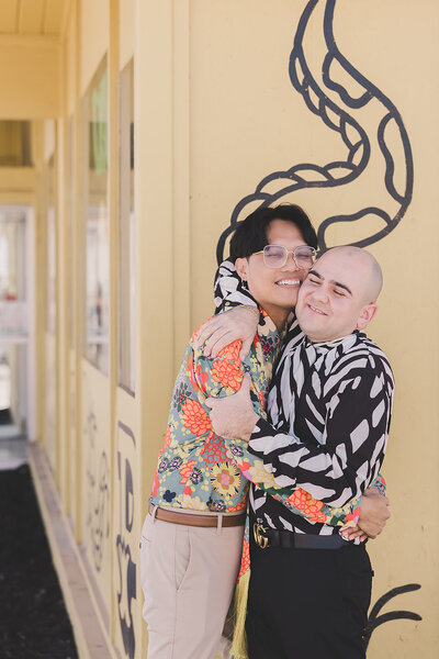 LGBTQ+ couple hug outside of tattoo shop after las vegas elopement