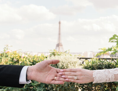 a bride and groom holding hands in front of Eiffel Tower