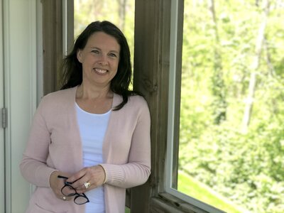 Rachel Sanford standing on screen porch holding glasses