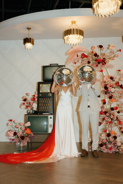 Bride and groom at a retro-themed wedding with disco balls and vibrant floral arrangements in Vancouver, captured by Vintage Gem Photography.