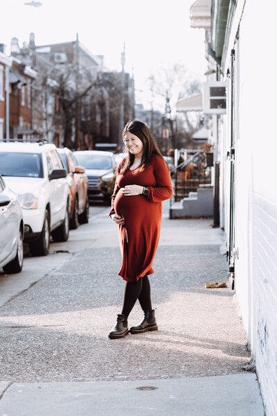 A sample image from Philadelphia wedding photographer Daring Romantics.  A couple cozies up together at their home. A pregnant young woman poses during her photoshoot outside in Philly.