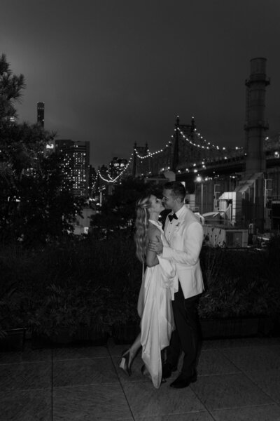 New York City elopement photo with the bridge in the background, sparkling in the night
