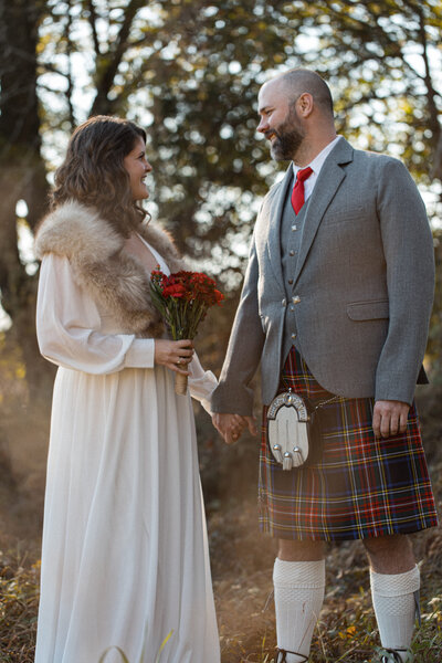 Groom wearing kilt and bride with a fur