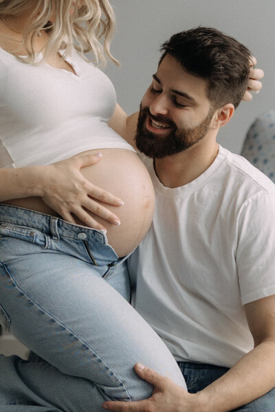 Man looking at woman's pregant belly at Finger Lakes maternity photography session