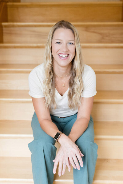 Parent coach Amy Fink sitting on a stair case