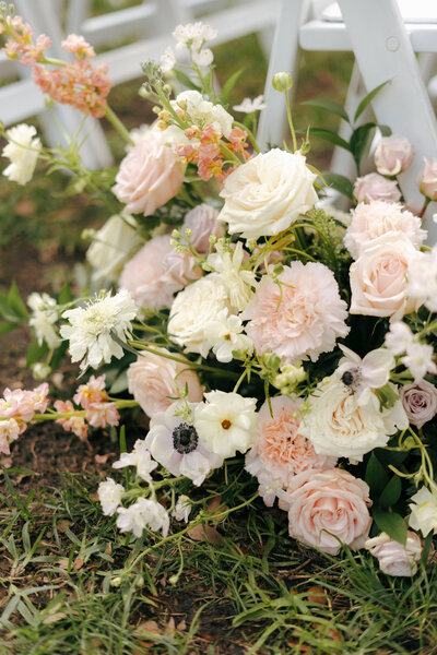 Close-up of a beautiful wedding flower bouquet with soft pastel blooms and greenery.