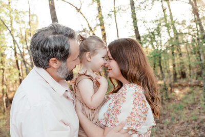 maternity photo featuring a brunette with curly hair in an orange boho dress at sunset