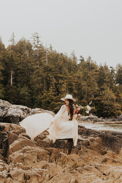 A bride poses on the wild coastline of Tofino, BC
